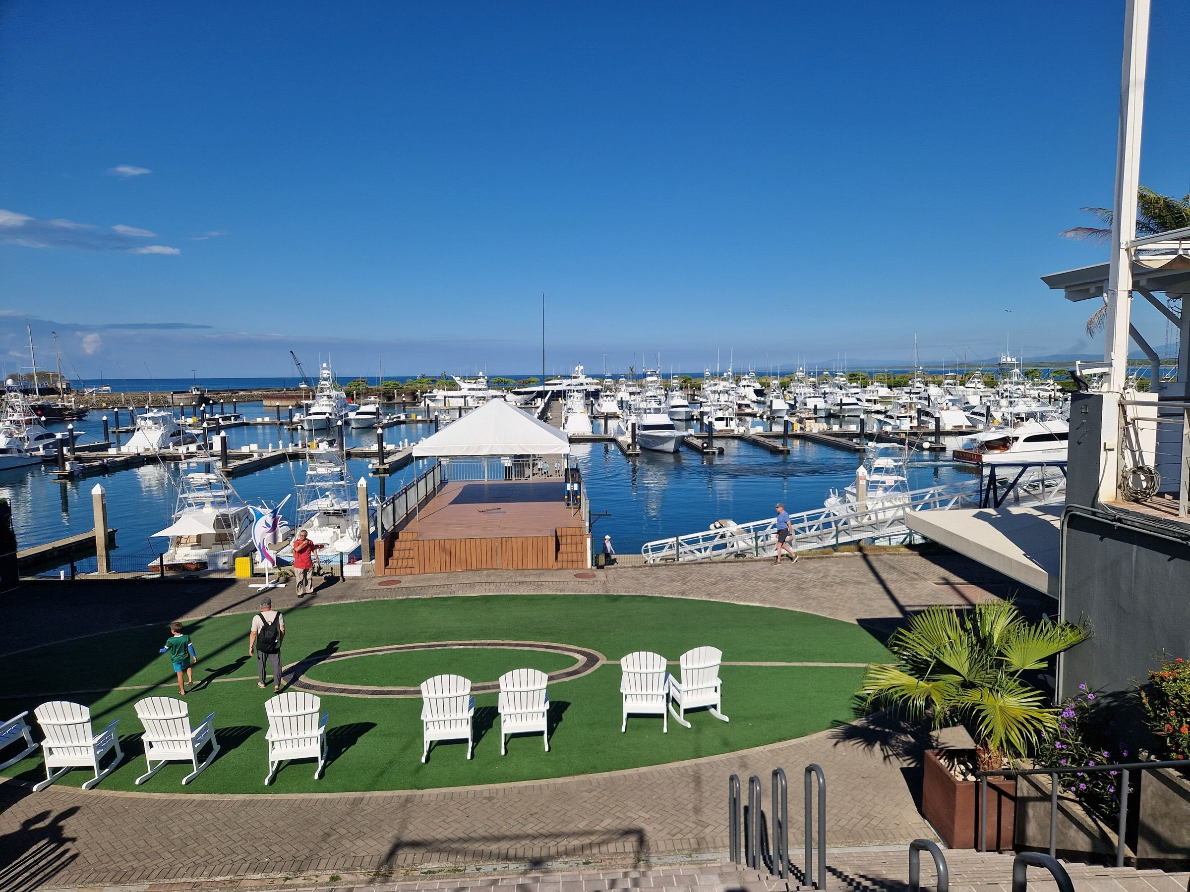 Lawn chairs on the marina village green overlooking the docks and moored yachts at Quepos Marina
