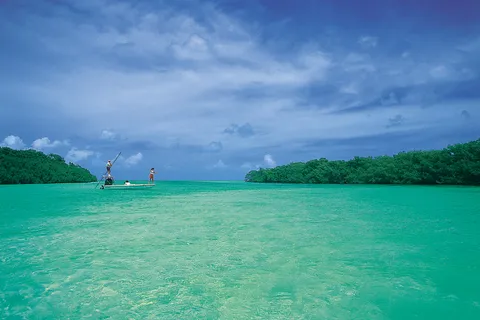 Two anglers flats fishing on clear aquamarine water between mangrove islands near Islamorada