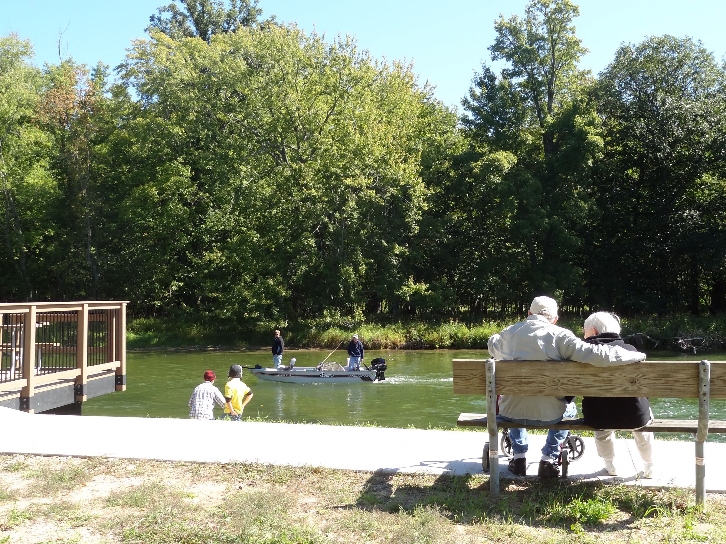 Anglers fishing from a small boat and the bank on the Manistee River at Rainbow Bend