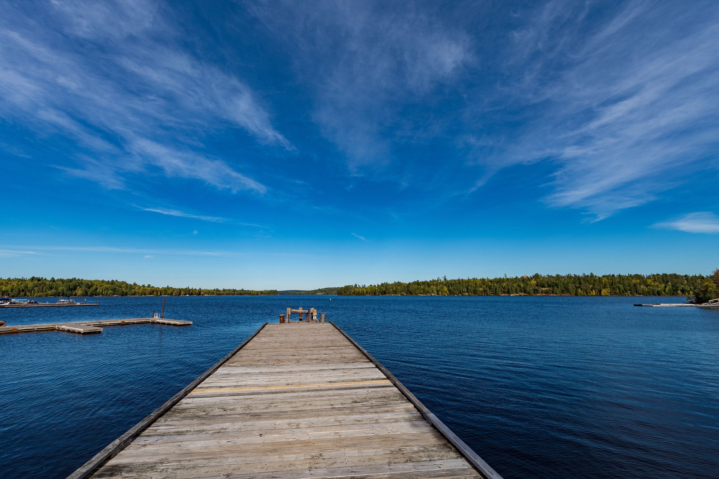 Wooden boat dock stretching into blue water on Crane Lake