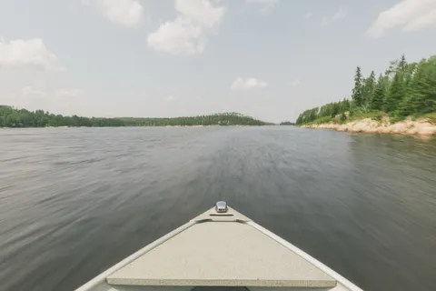 View from the bow of an aluminum boat running across a boreal lake near Kenora