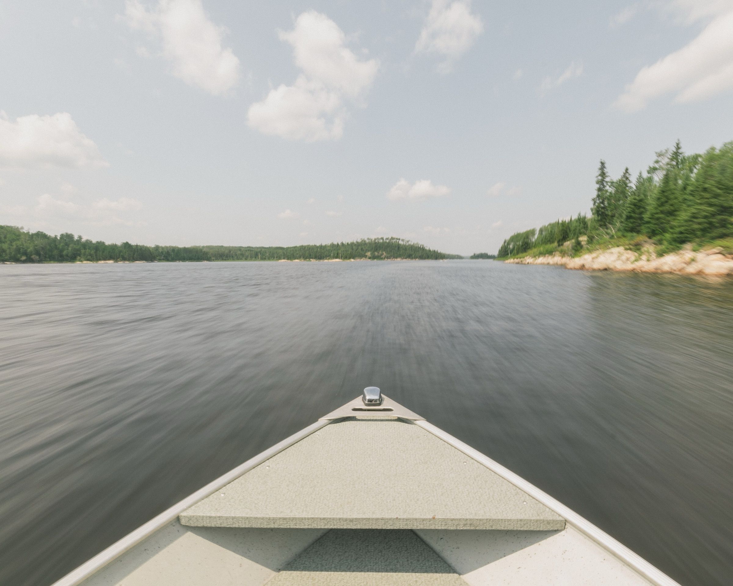 View from the bow of an aluminum boat running across a boreal lake near Kenora