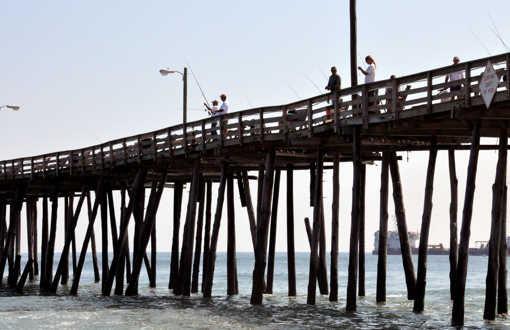 Anglers casting from the wooden Nags Head fishing pier above the Atlantic surf