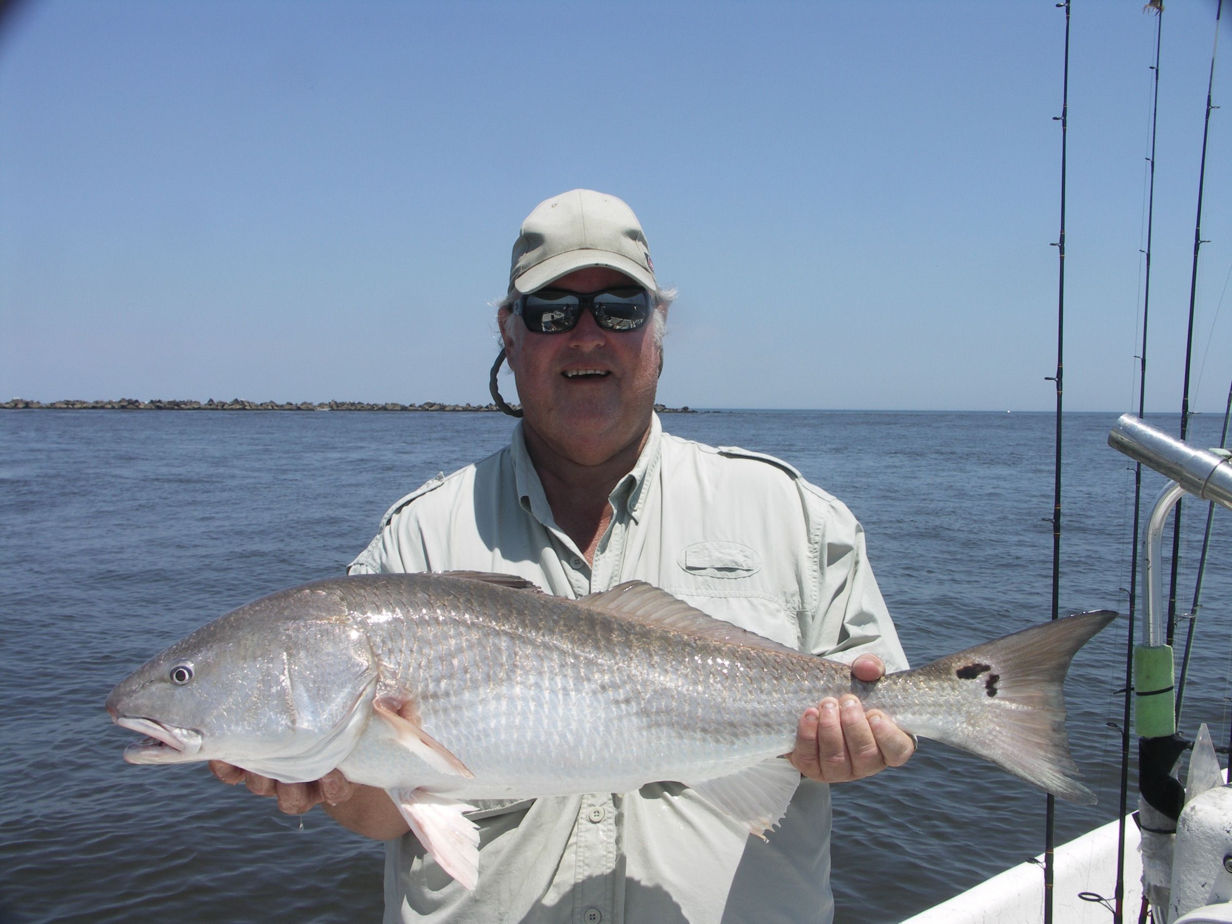 Fishing captain holding a redfish on a boat in Jacksonville