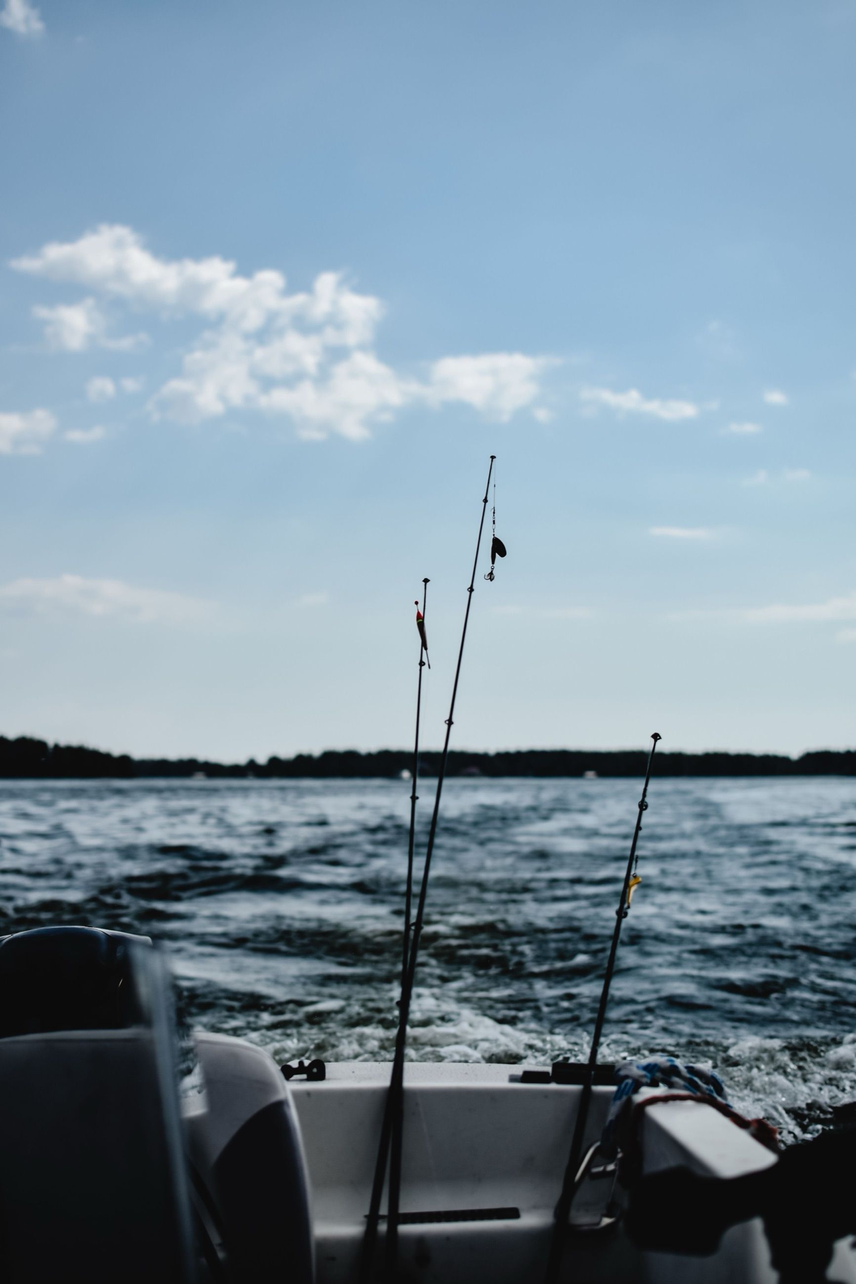 Fishing rods set in holders on a boat over open water
